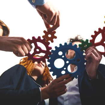 Teamwork of businesspeople work together and combine pieces of gears. Partnership and integration concept
